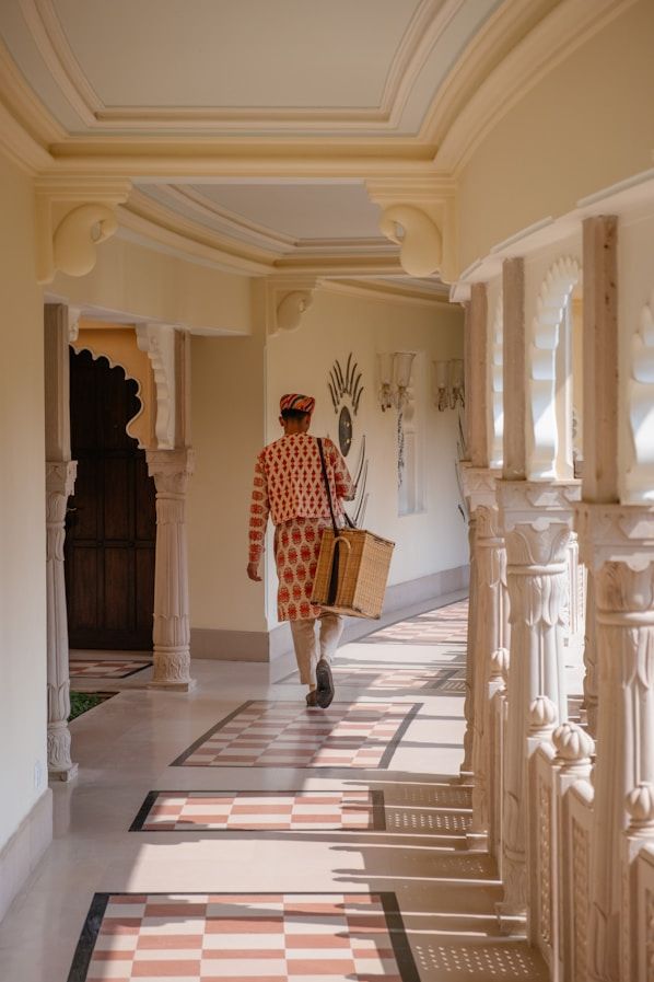man walking through a hallway carrying a suitcase