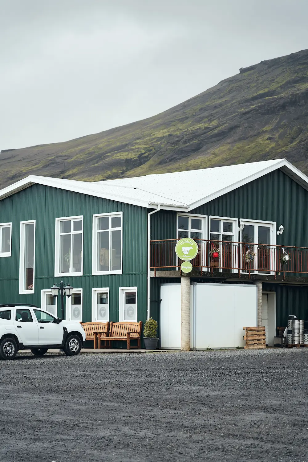 green building in iceland with mountain in the background